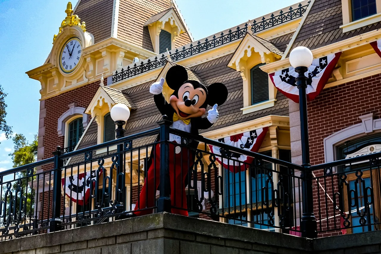 Mickey Mouse delante de la estación de tren de Main Street en Disneyland, California
