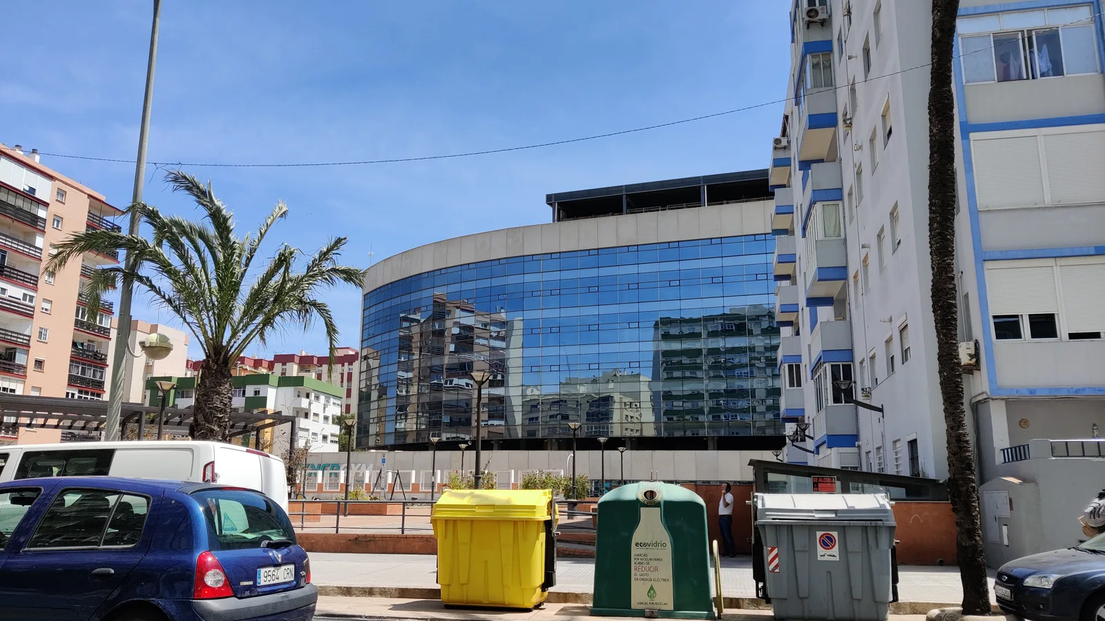 Fachada acristalada del estadio Nuevo Mirandilla, en Cádiz, con palmeras delante