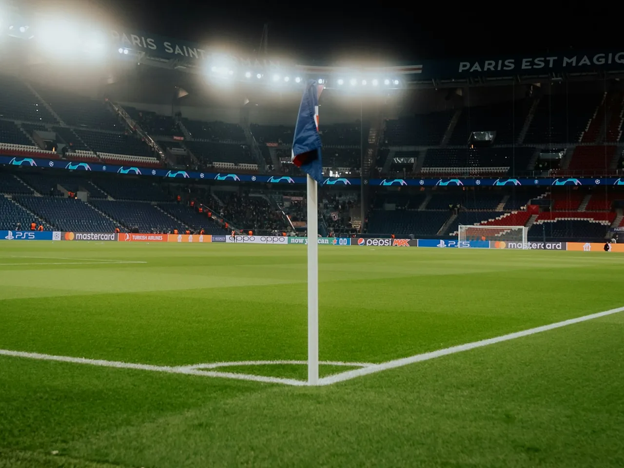 Banderín de córner sobre el césped de un estadio iluminado por la noche