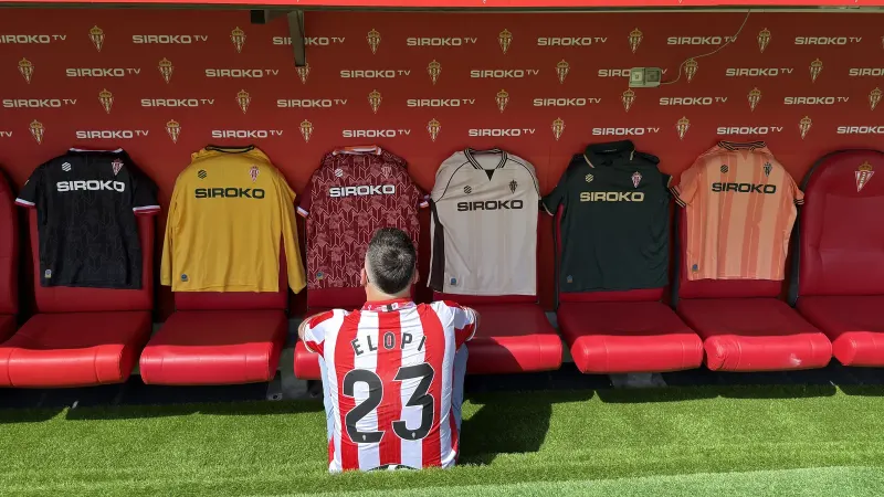 Las equipaciones del Real Sporting 2026/27 colgadas en el banquillo de El Molinón, con Elopi23 de espaldas con la camiseta ELOPI 23
