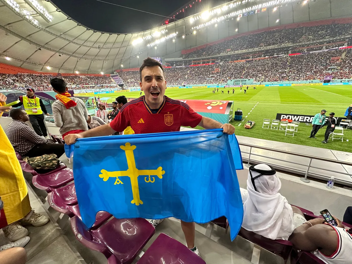 Elopi23 con la bandera de Asturias en la grada de un estadio del Mundial de Qatar 2022