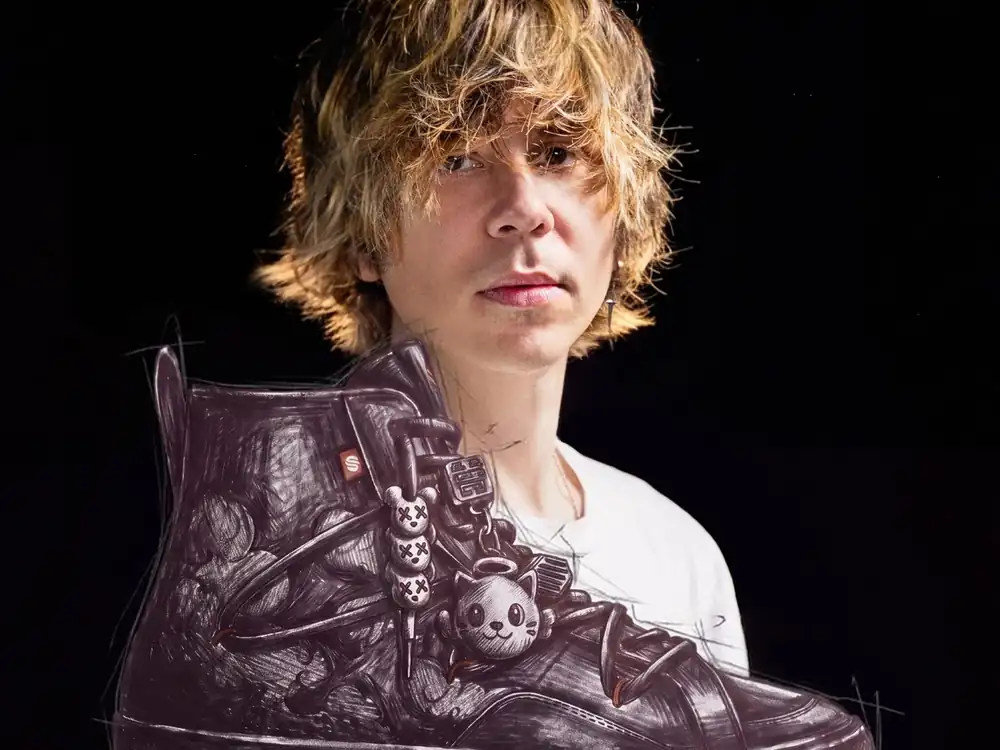 El Rubius sujetando el boceto ilustrado de la zapatilla MadKat x Siroko ONE con los charms de gato ángel